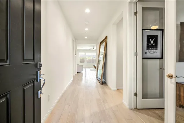 a view of a hallway with wooden floor and staircase