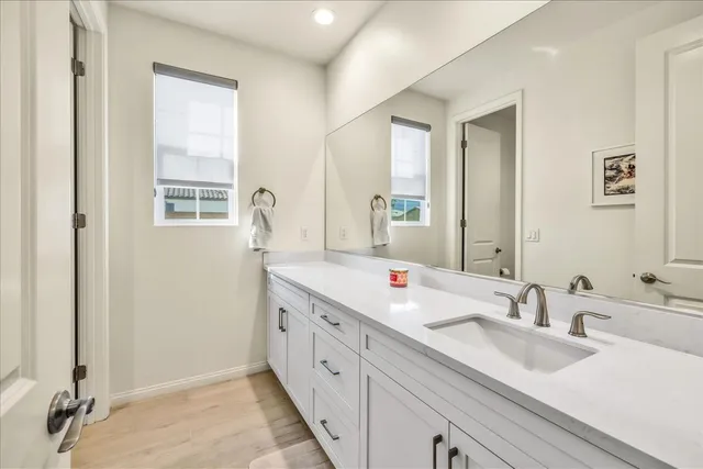 a bathroom with double vanity sinks and a mirror