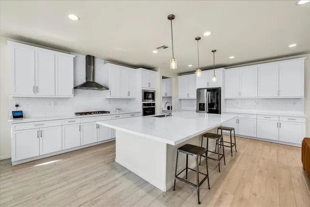 a kitchen with kitchen island a white counter space a sink appliances and cabinets