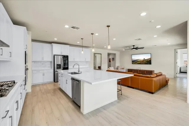 a large white kitchen with stainless steel appliances
