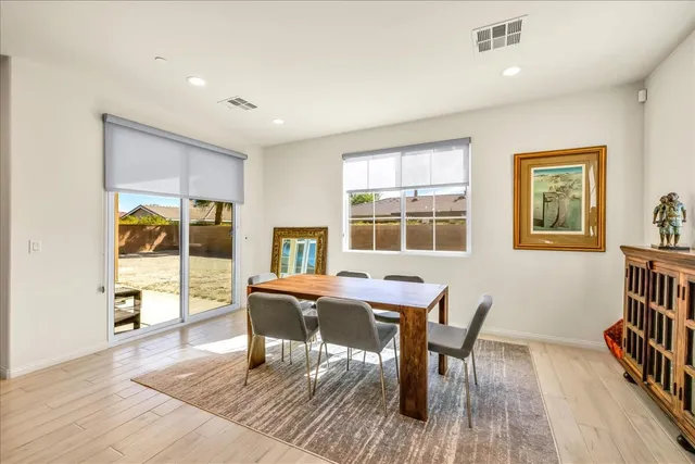 a dining room with wooden floor and windows