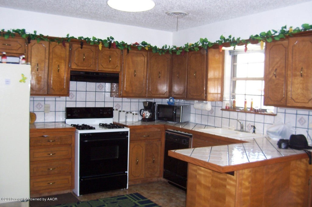5309 Capulin Lane Amarillo, TX 79110 - Photo 3 of 16 a kitchen with a stove a sink and a microwave
