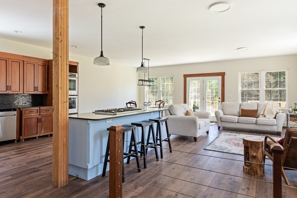 249 Blackmore Pond Road Wareham, MA 02576 - Photo 11 of 41 a living room with furniture a large window and a dining table with wooden floor