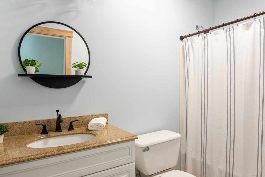249 Blackmore Pond Road Wareham, MA 02576 - Photo 18 of 41 a bathroom with a granite countertop toilet sink and mirror