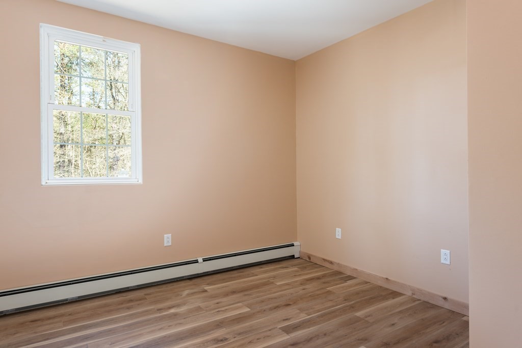 249 Blackmore Pond Road Wareham, MA 02576 - Photo 19 of 41 an empty room with wooden floor and windows