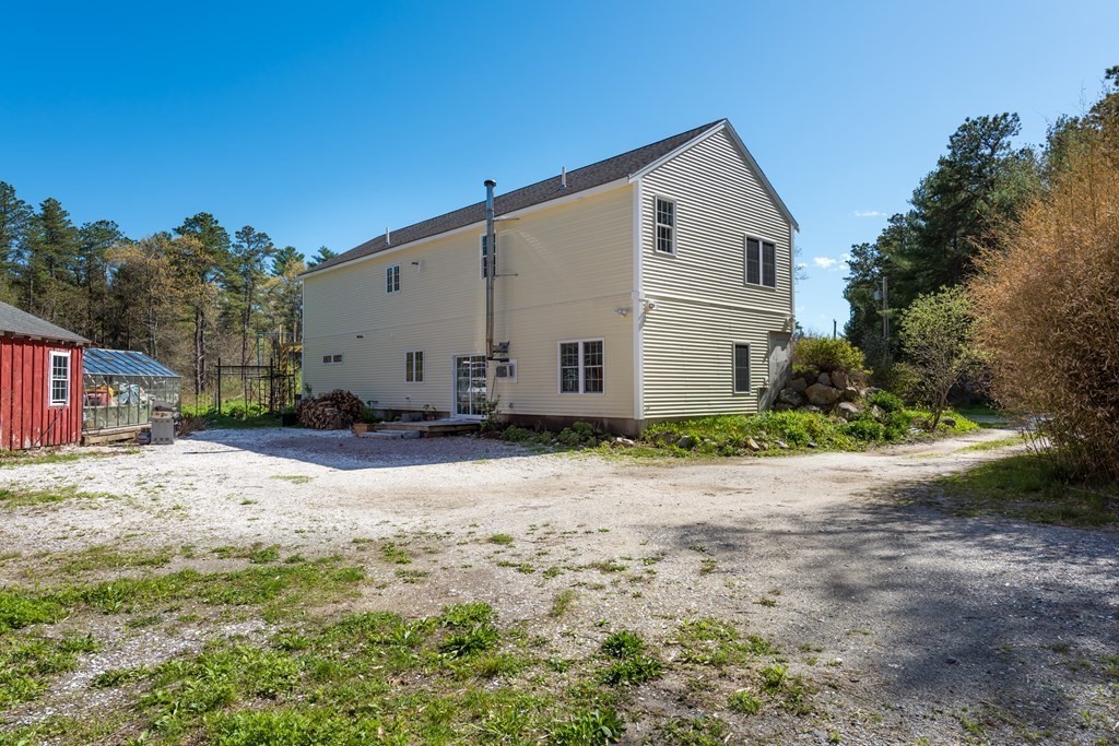 249 Blackmore Pond Road Wareham, MA 02576 - Photo 28 of 41 a view of a white house with a yard and large trees
