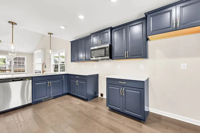 a kitchen with stainless steel appliances granite countertop wooden cabinets a stove top oven and granite counter top