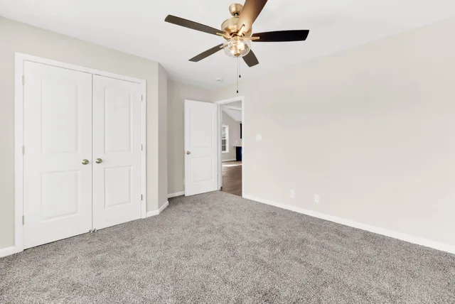 an empty room with chandelier fan
