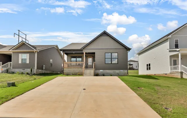 a front view of a house with a yard and trees