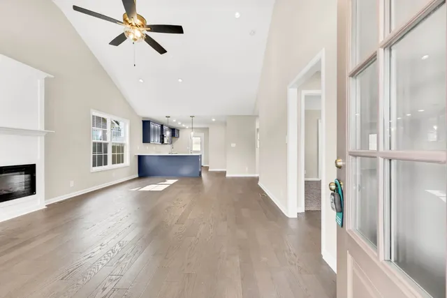 a view of empty room with wooden floor and fireplace