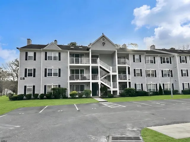 a view of a white house with a yard