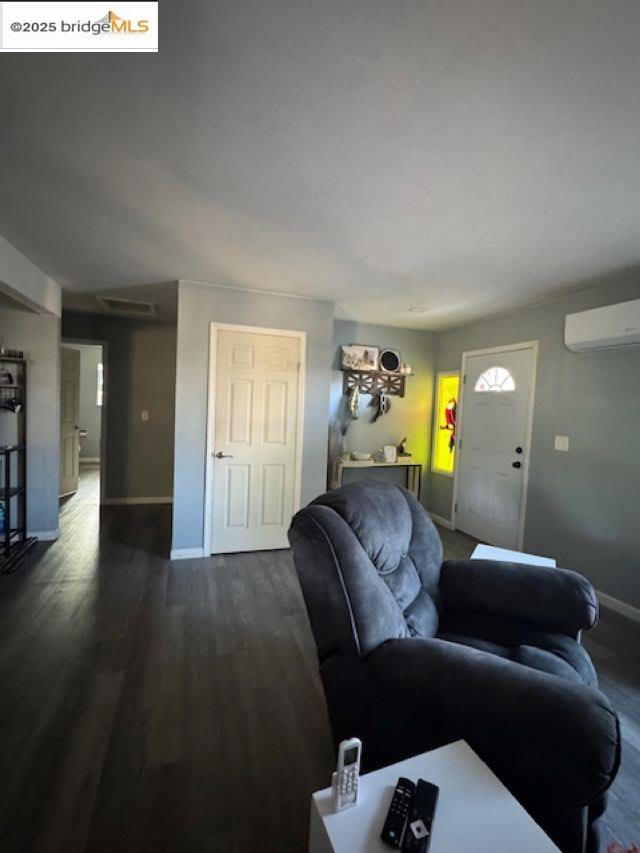 21890 Phoenix Lake Road Sonora, CA 95370 - Photo 19 of 22 Living room with dark wood-style floors and a wall mounted air conditioner