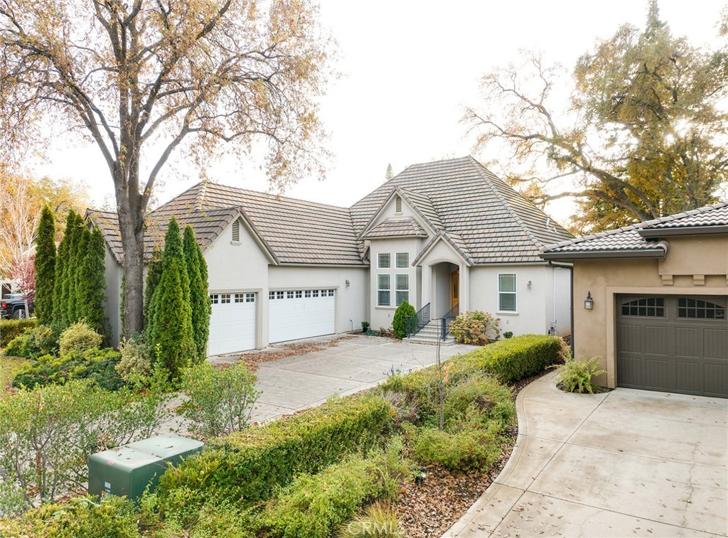 a front view of a house with a yard and potted plants