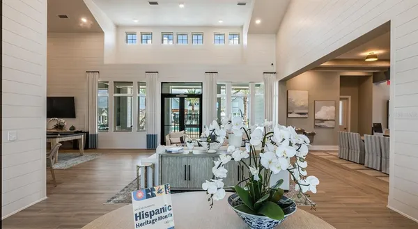 a living room with furniture large window and wooden floor