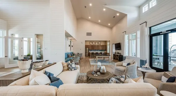 a living room with furniture kitchen view and a large window