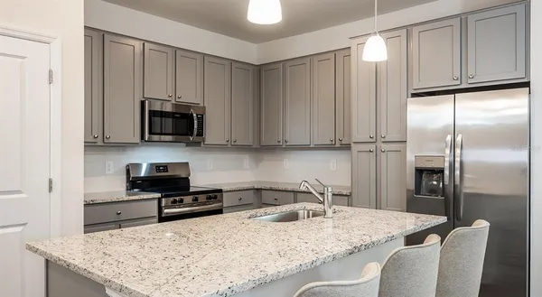 a kitchen with stainless steel appliances granite countertop a sink a stove and a microwave