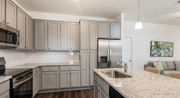 a kitchen with stainless steel appliances granite countertop a sink refrigerator and microwave