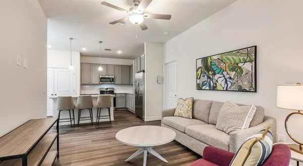 a living room with furniture a dining table and kitchen view