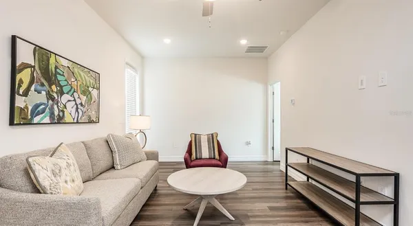 a living room with furniture and a wooden floor