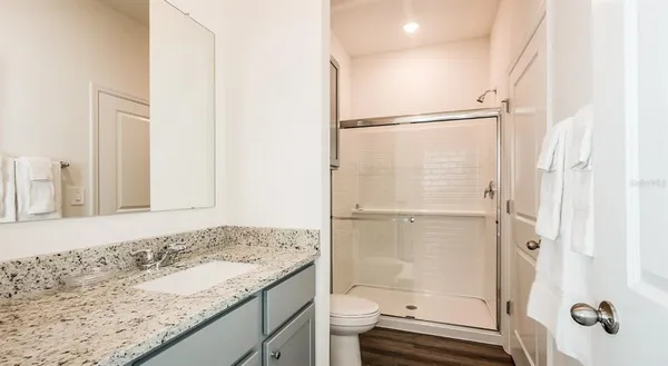 a bathroom with a granite countertop sink toilet and shower