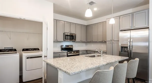 a kitchen with appliances cabinets and furniture