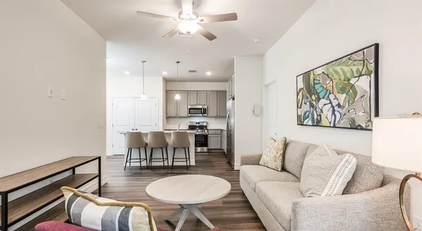 a living room with furniture a dining table and a chandelier