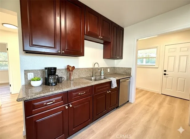 a kitchen with granite countertop wooden cabinets stainless steel appliances a sink and a window