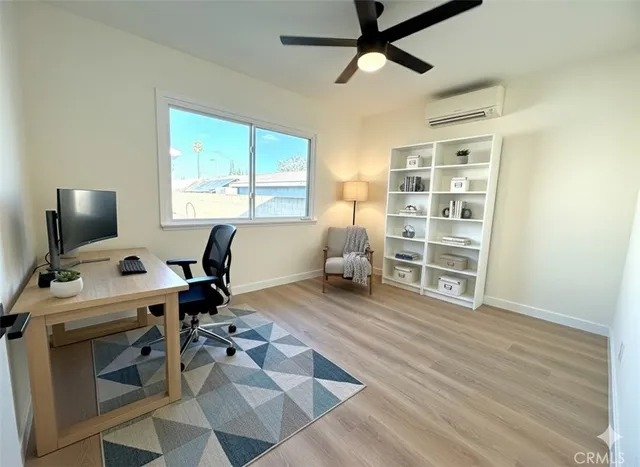 a view of a workspace with furniture and a window