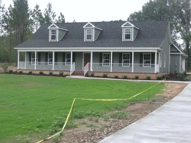 a front view of a house with a yard and trees