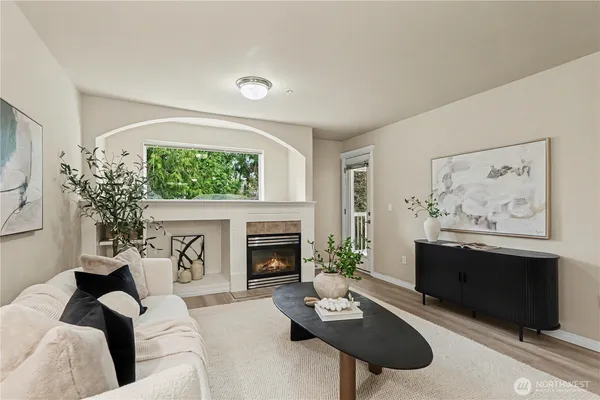 a living room with furniture a fireplace and a large window
