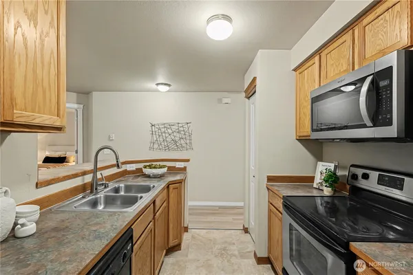 a kitchen with stainless steel appliances granite countertop a sink a stove and a microwave