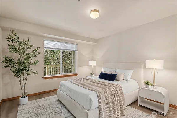 a bedroom with a large bed and a potted plant