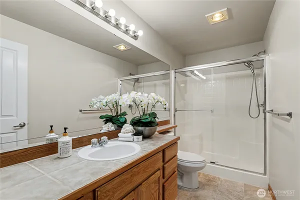 a bathroom with a granite countertop sink a toilet and shower