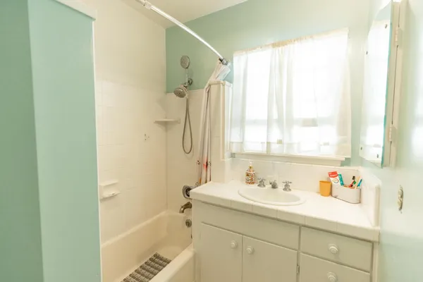 a bathroom with a tub sink and mirror