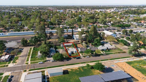 an aerial view of residential houses with outdoor space and trees