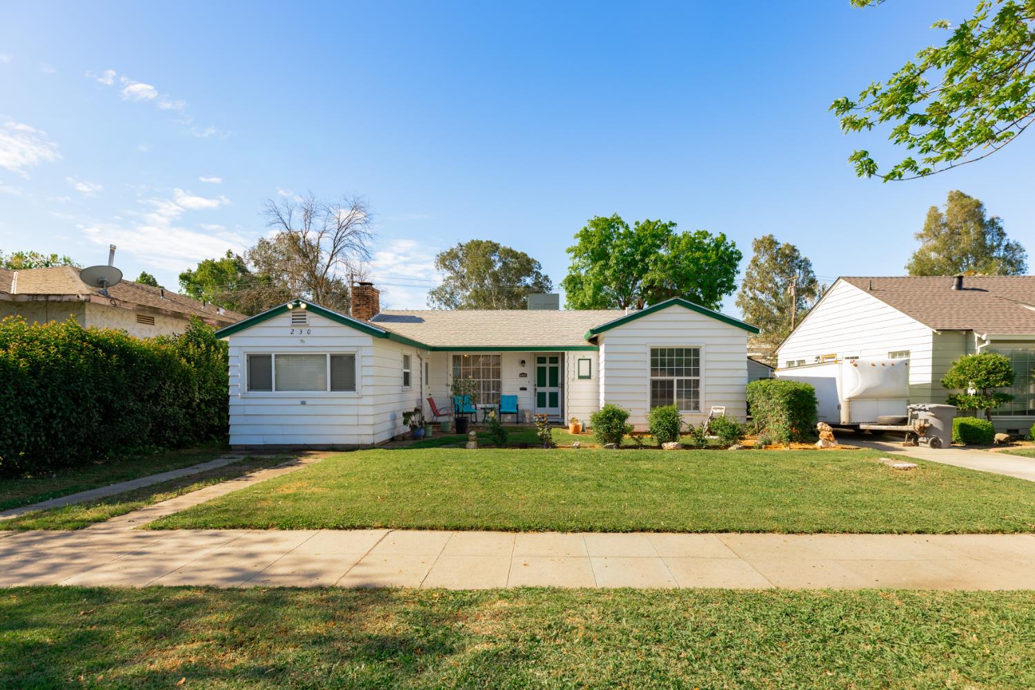 230 West 25th Street Merced, CA 95340 - Photo 3 of 20 a view of a house with a big yard and large trees