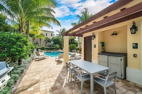 a patio with a table and chairs and potted plants