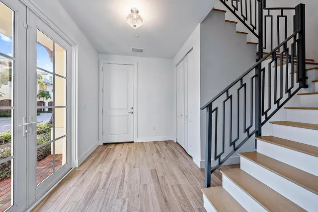 a view of a hallway with wooden floor and staircase