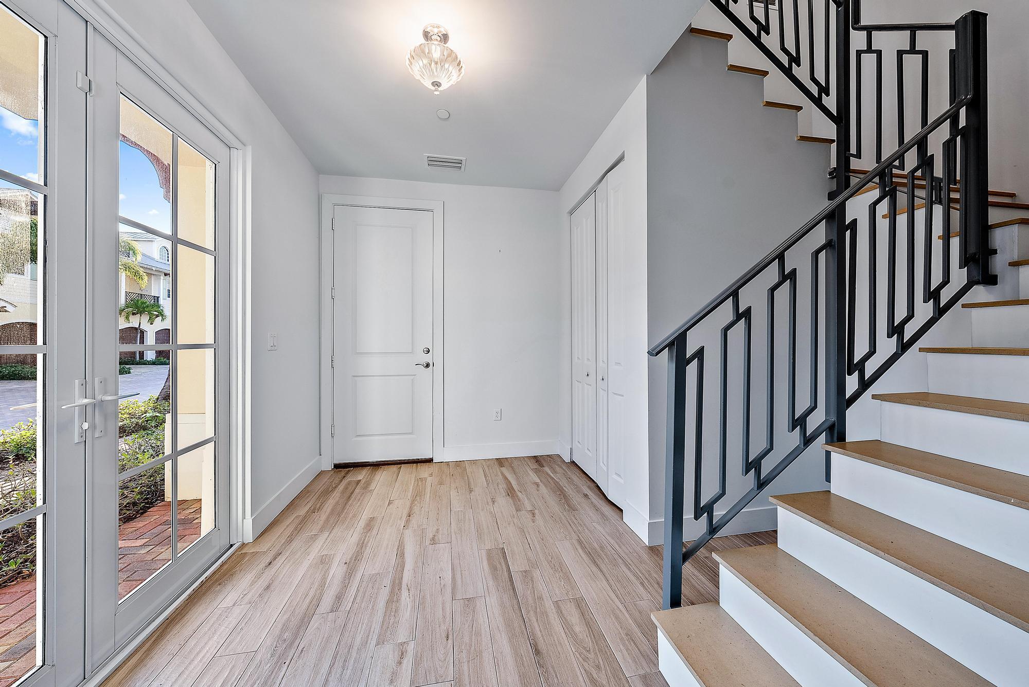 3770 County Line Road Tequesta, FL 33469 - Photo 14 of 42 a view of a hallway with wooden floor and staircase