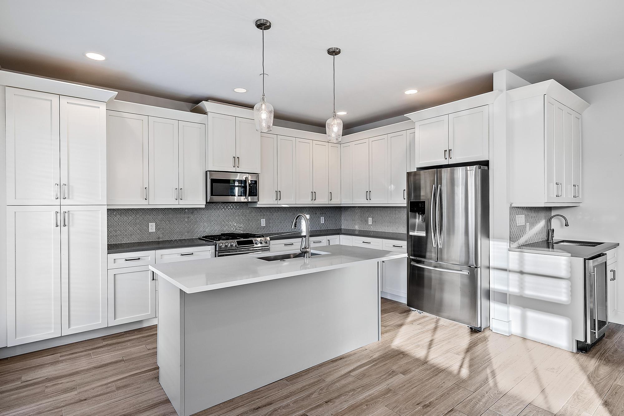 3770 County Line Road Tequesta, FL 33469 - Photo 20 of 42 a kitchen with stainless steel appliances granite countertop a refrigerator a stove a sink and white cabinets with wooden floor