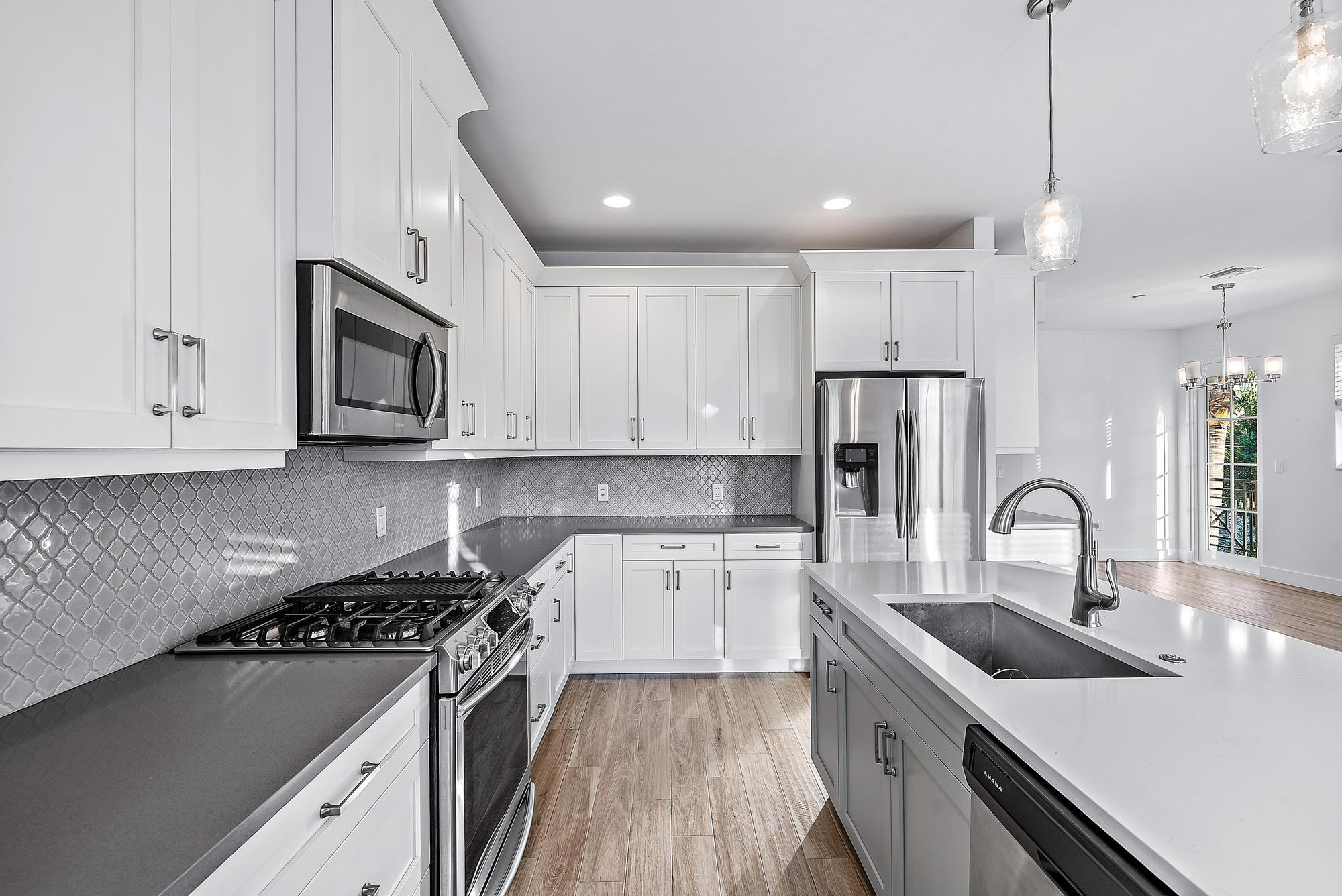 3770 County Line Road Tequesta, FL 33469 - Photo 23 of 42 a kitchen with a sink stove and refrigerator