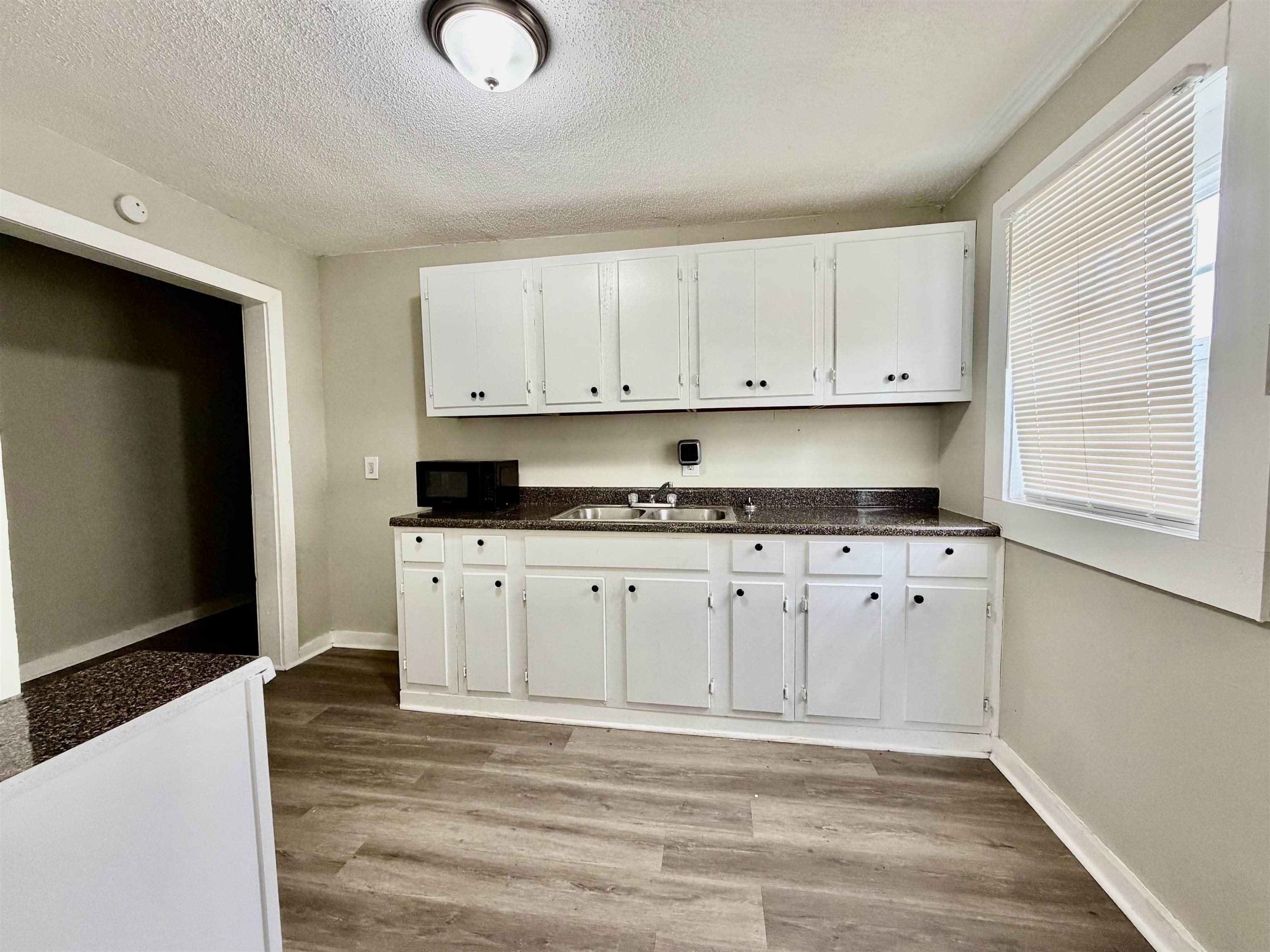 1448 Menager Road Memphis, TN 38106 - Photo 15 of 17 a kitchen with granite countertop white cabinets and stainless steel appliances