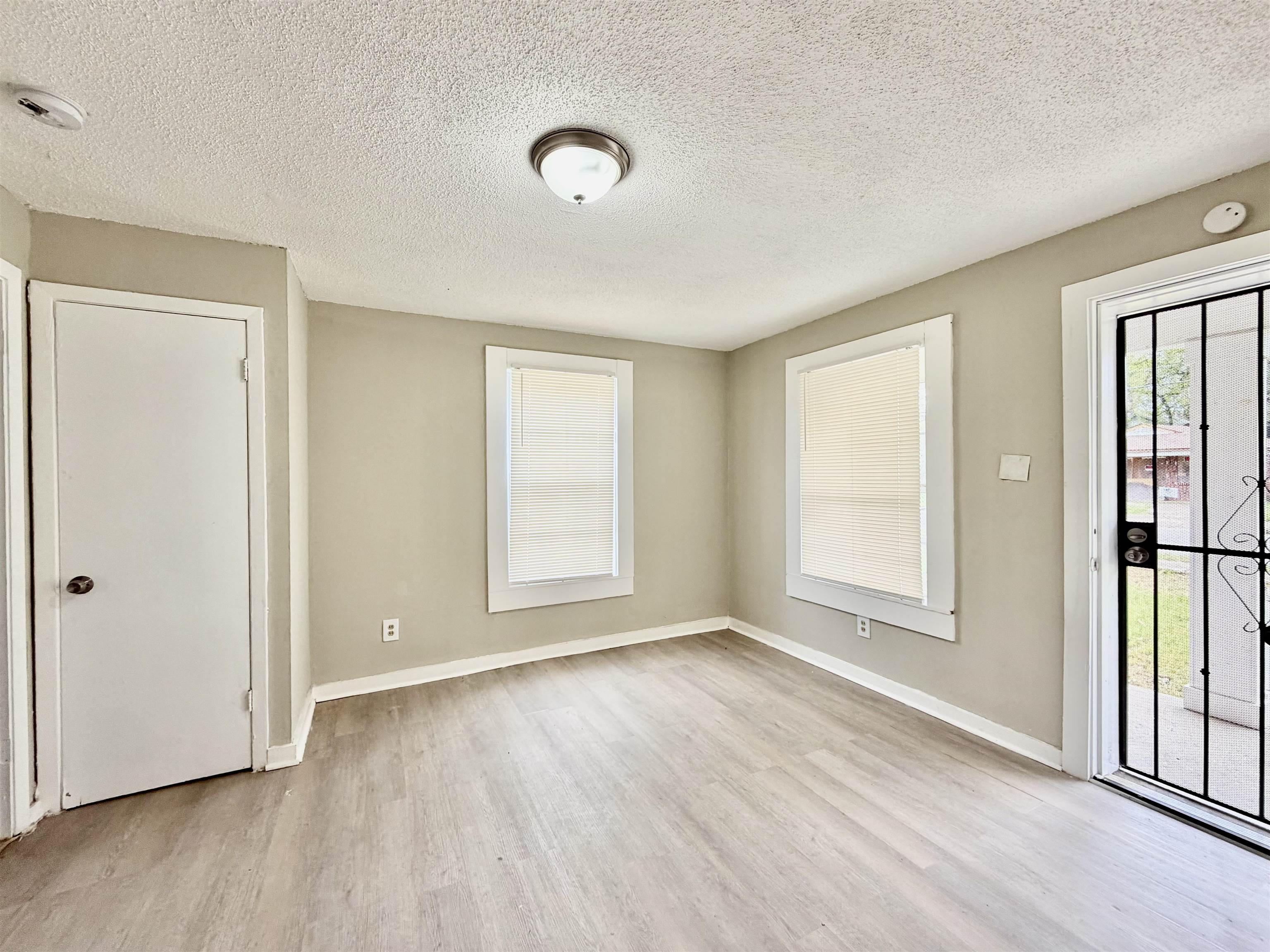 1448 Menager Road Memphis, TN 38106 - Photo 16 of 17 an empty room with wooden floor and windows