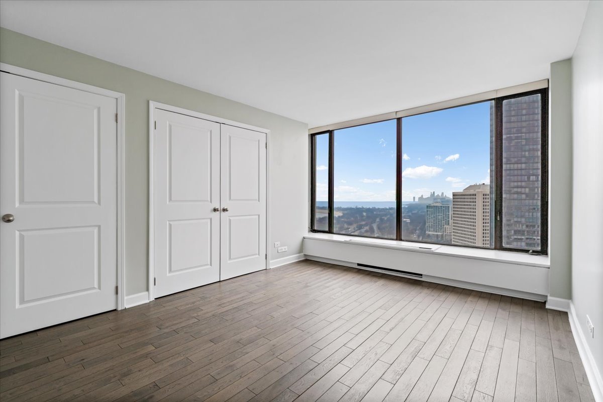 5455 North Sheridan Road, Unit 3406 Chicago, IL 60640 - Photo 18 of 30 a view of an empty room with wooden floor and a window
