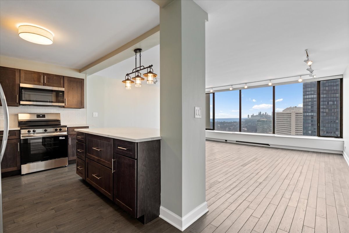 5455 North Sheridan Road, Unit 3406 Chicago, IL 60640 - Photo 2 of 30 a kitchen with stainless steel appliances granite countertop a stove and a wooden cabinets