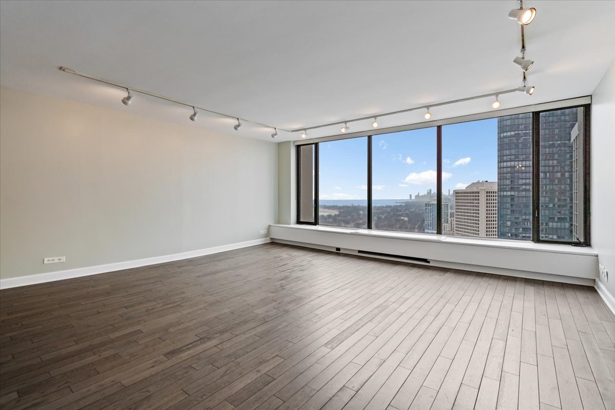 5455 North Sheridan Road, Unit 3406 Chicago, IL 60640 - Photo 4 of 30 a view of an empty room with wooden floor and a window