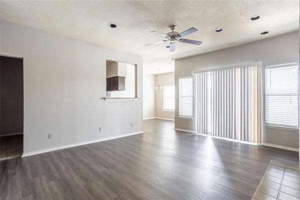 a view of an empty room with wooden floor and window