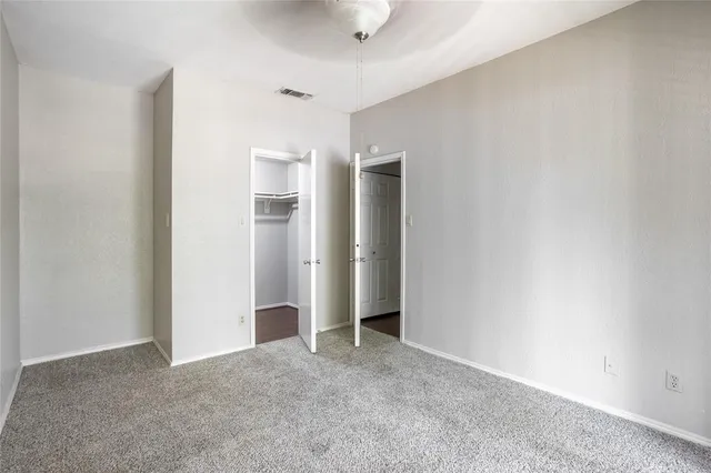 a view of an empty room with closet and entryway