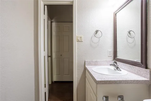 a bathroom with a granite countertop sink a mirror and shower