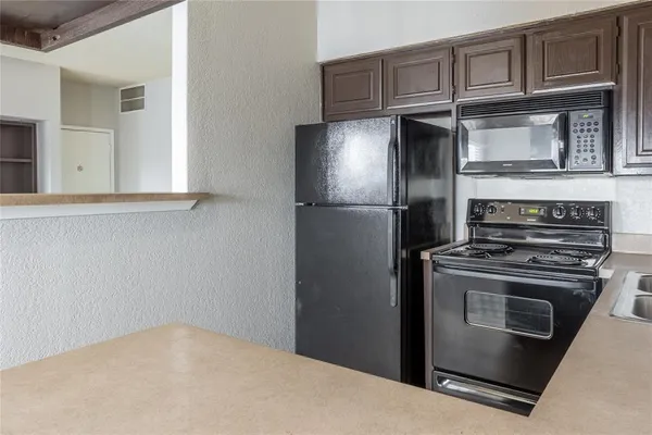 a kitchen with stainless steel appliances granite countertop a refrigerator stove and cabinets